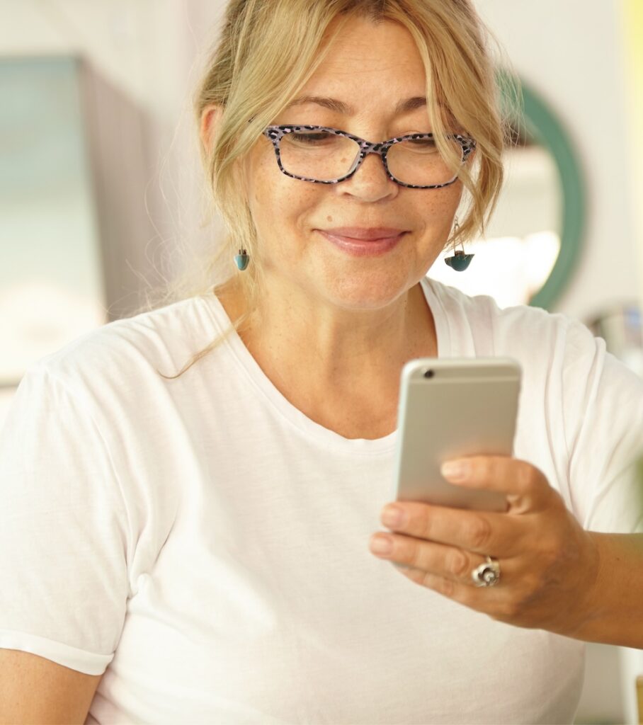 Patiente consultant ses symptômes sur son smartphone à domicile